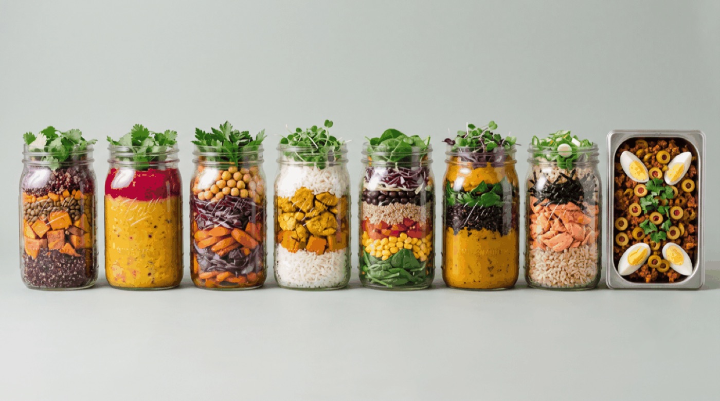 A week of Frasco dinners lined up in glass jars with one stainless tray